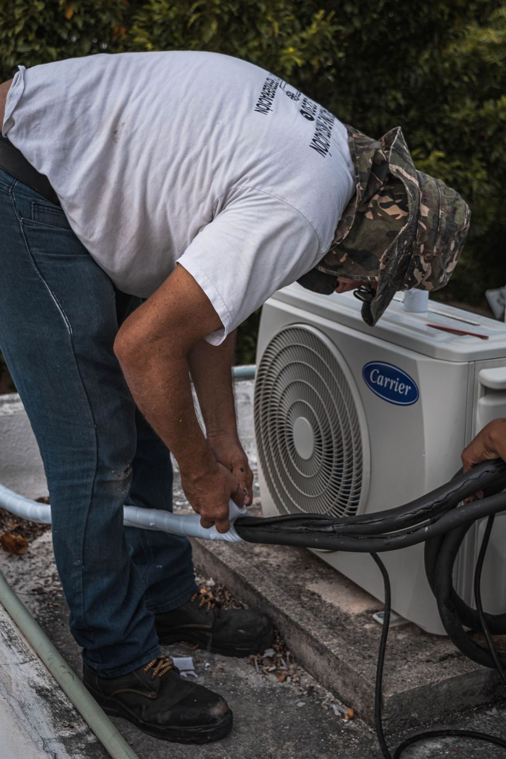 Technician connecting refrigerant lines to an outdoor air conditioning unit